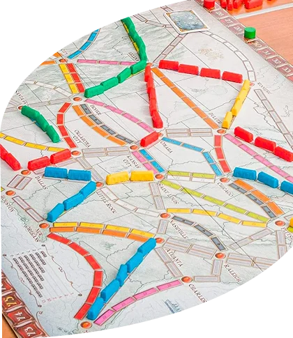 Een bordspelopstelling met een kleurrijke kaart waarop verschillende sporen zijn aangegeven met kleine gekleurde treinfiguren. De kaarten en speelstukken liggen er netjes omheen.